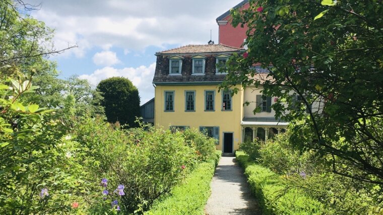 Rückansicht von Schillers Gartenhaus mit sommerlichem Garten